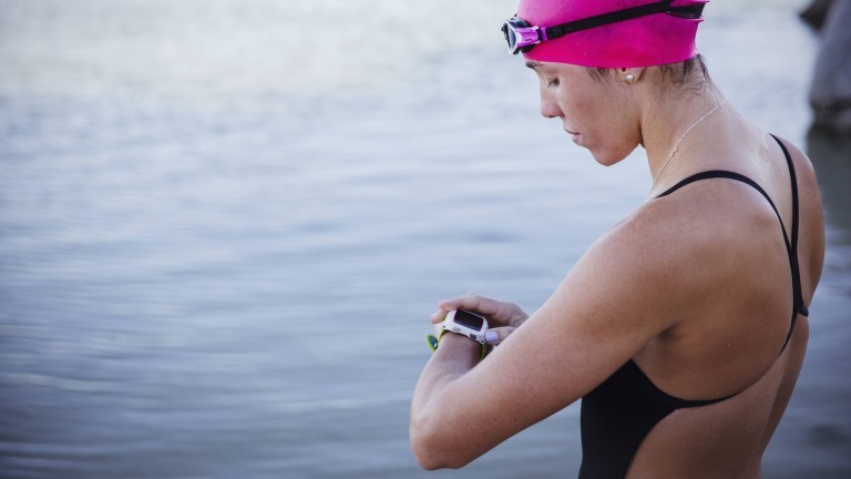 A person swimming with a fitness tracker on their wrist.