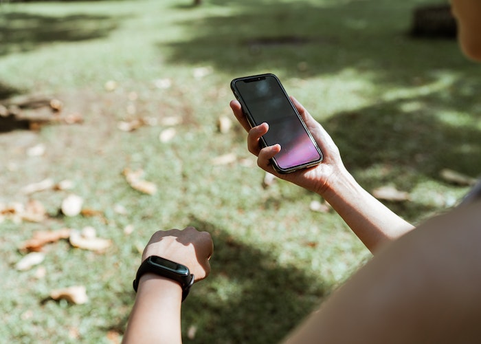 A person resting after a workout, checking their smartwatch for heart rate recovery.