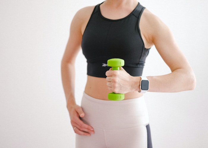 A person holding a fitness tracker, looking relaxed after a workout, checking their heart rate recovery.