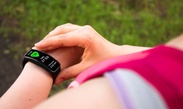 A person measuring their resting heart rate using a fitness tracker.