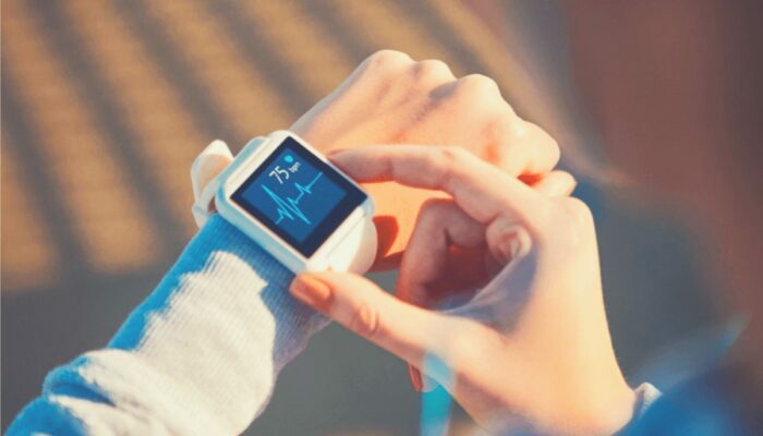 woman using a heart rate monitor to manage stress.