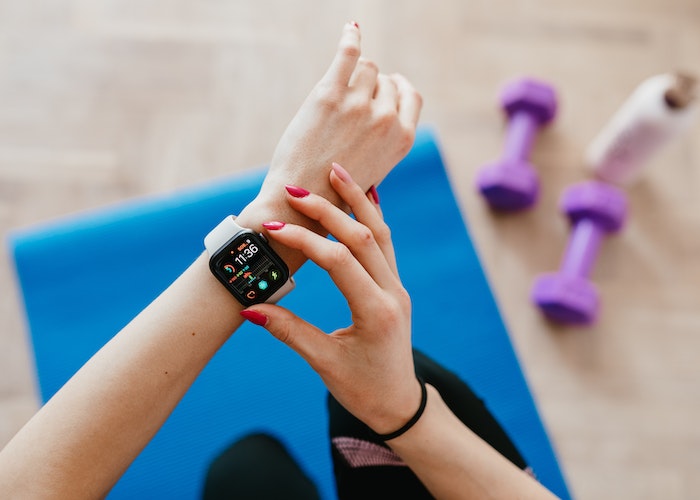 A person wearing a fitness tracker on their wrist, monitoring heart rate during exercise.
