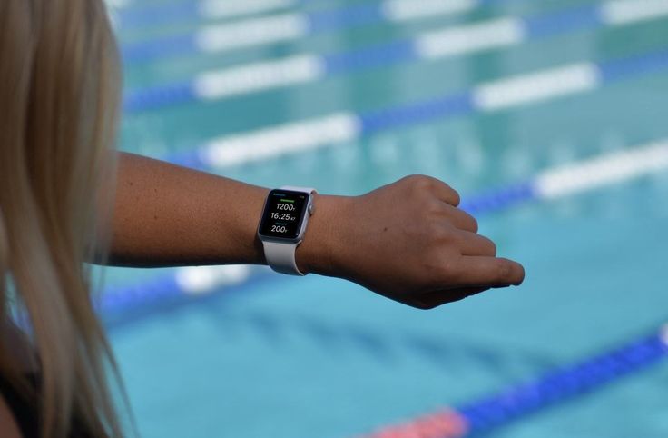 A person using wearable technology, wearing a smartwatch and fitness tracker.